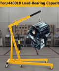 4000 LB Folding Engine Crane Beefy Steel Hoist Cherry Picker Portable Garage Lift For Auto Repair Workshop lifting a car engine in a workshop.