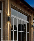 Modern Led Outdoor Wall Sconce,2-Pack 20w Updown Wall Wash Light,Black Metal Ip65 mounted on brick wall, illuminating entrance.