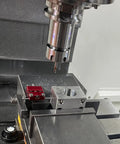 Precision Adjustable Vise Work Stop And Quick Clamp Jaw Featuring Hella Tough Red Anodized Aluminum Build in CNC setup with drill bit.