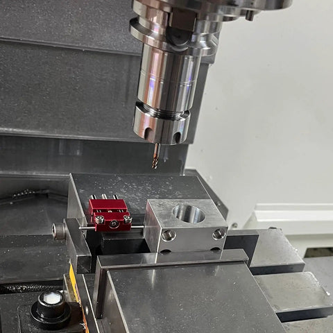 Precision Adjustable Vise Work Stop And Quick Clamp Jaw Featuring Hella Tough Red Anodized Aluminum Build in CNC setup with drill bit.