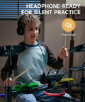 Child using Kids Electric Drum Set 7 Piece With Quiet Silicone Pads And 9 Inch Cymbals, 150 Sounds And 15 Kits for practice