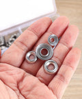 Close-up of stainless steel cup countersunk finishing washers, assorted #6–#12, held in hand.