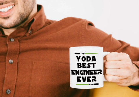 Man holding ceramic mug with text 'Yoda Best Engineer Ever' part of Funny Engineer Mug For Men And Women A Totally Dope Graduation Gift For Engineers And Students And STEM Lovers Mechanical Civil Science And Math Coffee Cup Keepsake.