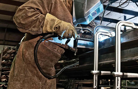 Welder using Beefy Heavy Duty F Clamp With 12 Inch Opening And Five And A Half Inch Throat Delivers 2660 Lbs Clamping Force For Tough Jobs