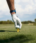 Gloved hand placing unbreakable premium plastic golf tee on a golf course, consistent height, multiple sizes available, 4 pack