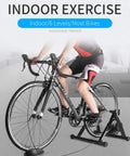 Person using All Weather Indoor Bike Trainer Stand With Magnetic Resistance For Home Gyms Fits 26 To 29 Inch And 700C Wheels