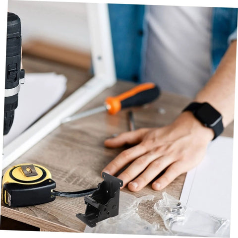 Folding table hinge replacement kit with tools on wooden desk for DIY furniture repairs.