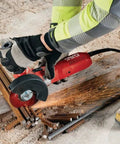 Worker using Professional Grade 1300W 230V Angle Grinder Featuring 125MM Disc Size for metal cutting on construction site.