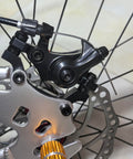 Close-up of bike's front mechanical disc brake caliper with 160mm rotor, part of Front And Rear Bike Disc Brake Kit With 160mm Rotors Calipers Cables Levers And Fixing Screws Stainless Steel Mechanical System For Upgrading Bikes For Daily Ride And Reliable Stopping.