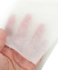 Hand-held sheet of white lens cleaning paper (10×15 cm) for eyeglasses and camera lenses.