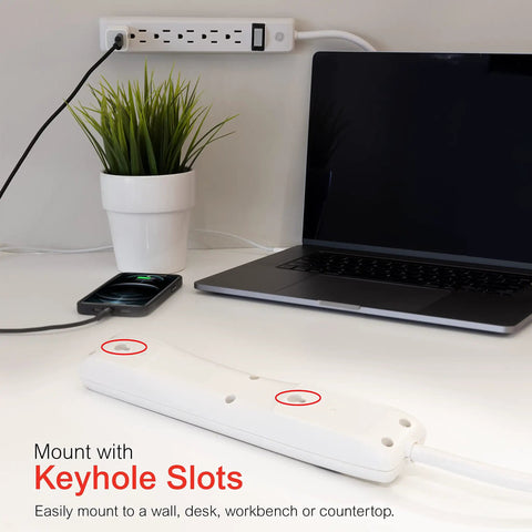 Six Outlet Power Strip Four Pack With Two Foot Extension Cords for home office on desk with laptop, plant, and charging phone