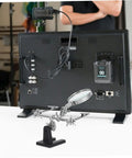 Adjustable Third Hand Soldering Station With Magnifying Glass And Dual Alligator Clips in front of electronic equipment