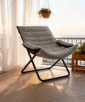 Three Position Adjustable Folding Recliner Chair With Ottoman And Armrests For A Comfy Portable Lounge In Gray on balcony