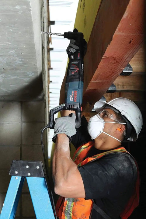 Worker using Reconditioned Bulldog Xtreme 1-Inch SDS-Plus D-Handle Rotary Hammer With Variable Speed, 7.5 Amp for overhead drilling