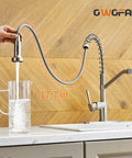 Brushed Nickel Kitchen Faucet With Pull Down Sprayer, Single Handle, showing water flowing into a pitcher on a countertop