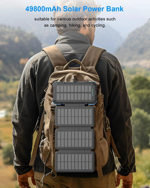 All-In-One Solar Power Bank 49800mAh with 4 Built-In Cables and 3 Foldable Panels attached to a hiker's backpack in nature
