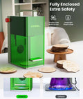 Front view of green xTool F1 2-in-1 laser engraver with transparent enclosure, red stop button, and handle on a desk.