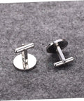 Pair of silver cufflinks on grey fabric background, circular design suitable for formal and business shirts