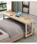 Roomy Rollin Overbed Laptop Desk Featuring Sturdy Guard Rail And Smooth Lockable Wheels Solid Wood Bedside Tray with laptop on it