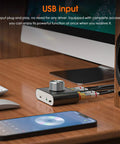 Mini Pocket Bluetooth 5.0 Amp Delivers 100W Stereo Output, 50W Per Channel, with AUX USB Input on wooden desk next to computer.