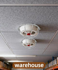 Heavy Duty Metal Detector Guard Cover And Fire Alarm Protector With Tool Less Quick Mount For Sprinkler Heads And Smoke Sensors In Homes Offices Hotels Garages And Commercial Buildings Built Tough To Keep Things Secure installed on ceiling in a warehouse.