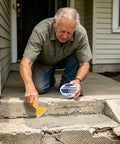 Man applying Heavy Duty Concrete Crack Filler Masonry Sealant to fix crumbling stair edges on outdoor steps.
