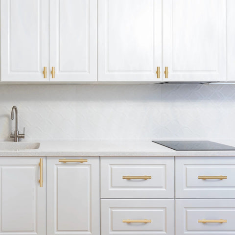 Modern kitchen featuring 6-Pack Solid Brass Cabinet Pulls in Brushed Gold Finish, single hole centers, on white cabinets.