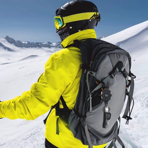Person skiing wearing backpack with Two Pack Heavy Duty Retractable Keychain Carabiner Badge Holder Set With 32 Inch Steel Cord Tactical ID Badge Reel