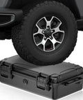Beefy ABS Tool Organizer Box With IP67 Waterproof Rating and Pressure Equalization system under vehicle tire, showing durability.