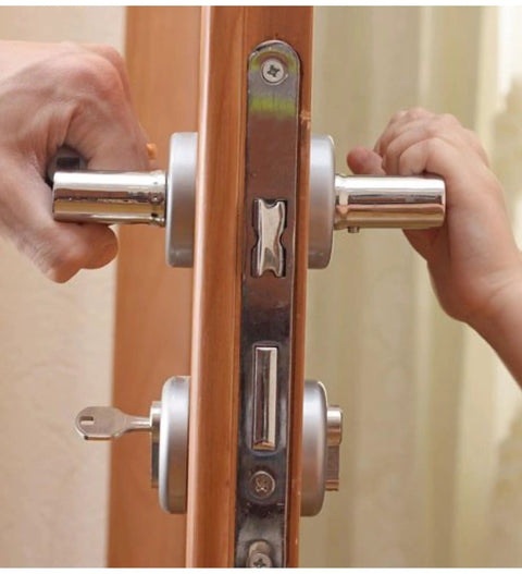 Close-up of a door lock mechanism with two people turning handles, illustrating the use of the Graphite Lubricant Powder Bundle.