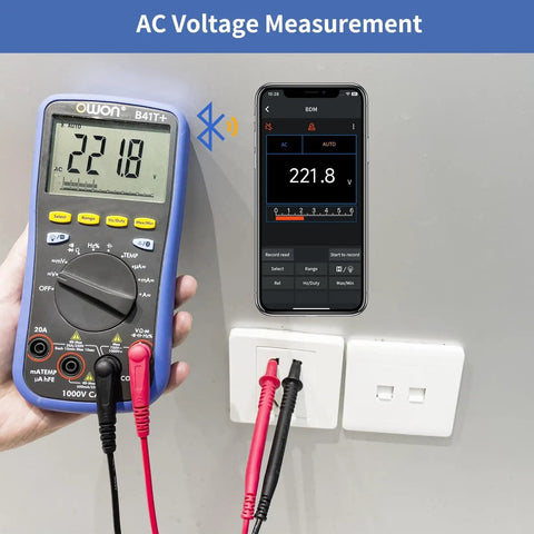 B41T Bluetooth Digital Multimeter measuring AC voltage, connected to outlet, displaying 221.8V with mobile app sync.