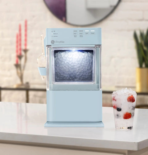 Portable Countertop Nugget Ice Maker Delivers Sick Chill Levels With Legit Chewable Snow Ice Ready Fast Features near a glass of ice.