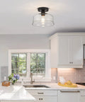 Semi Flush Mount Ceiling Light With Seeded Glass Shade in Black Finish in a modern kitchen setting.