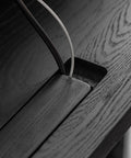 Close-up of cord management system on Super Sturdy Electric Standing Desk With Dual Storage Drawers And Whisper Quiet Lift Features A Heavy Duty Ash Wood Desktop In Crisp Matte Black.