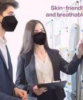 Two professionals wearing black KN95 face masks from 50 pack disposable respirators with 5 layer design, working in an office.