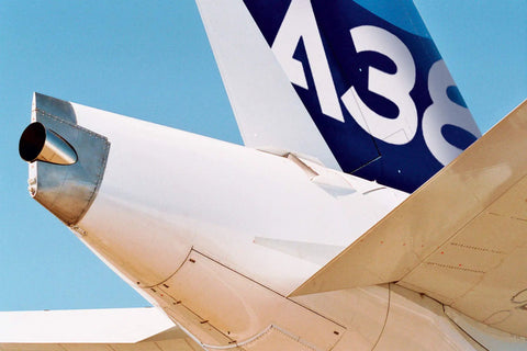 Close-up of 1:144 scale Airbus A380 model kit tail section, detailed multicolor plastic, requires assembly and painting.