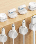 8 Pack Cord Organizer With 1s Spring Lock Cable Clips for desk use, showing white adhesive holders managing phone chargers and USB cables.