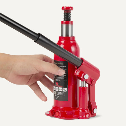 Amazon Basics red hydraulic bottle jack with long black handle, side view