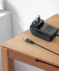 Top Shelf Replacement AC Adapter For Skil And Bosch Handheld Power Tools Straight 6V Output Charger on wooden table with plug.