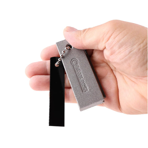 Hand holding the Magnesium Fire Starter Kit Portable Waterproof Survival Tool For Camping Hiking Bushcraft And Emergency Prep.