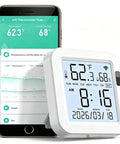 Smart Temperature And Humidity Monitor With Large Backlit LCD Screen, Real Time App Alerts, Indoor Hygrometer next to smartphone.