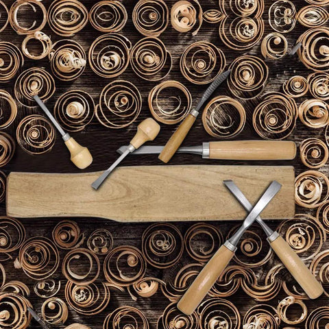 Heavy Duty 16 Piece Wood Carving Tool Set With Premium Handles Sharp Chisels And Gouges Includes Wooden Mallet And Whetstone For Absolutely Kickass Detail Craftsmanship on wooden surface with curled shavings.