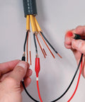 Hands using a Remote And Local Continuity Tester With Detachable Remote Probe Audible Tone Long Distance Cable Testing.