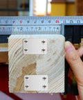 Heavy-Duty Stainless Steel Flat Corner Braces With Screws on wood block with measurement tool shown