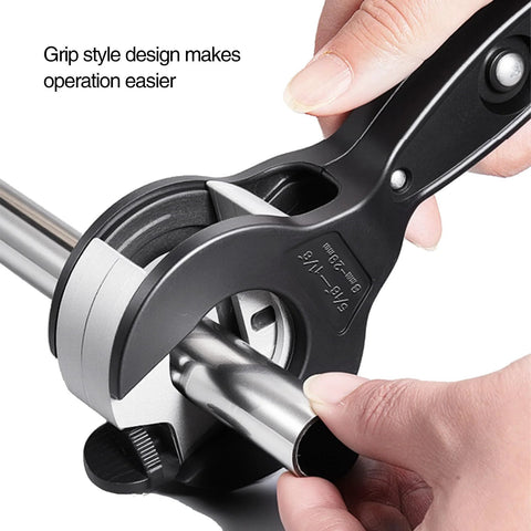 Front view of a compact ratchet pipe cutter around a steel pipe; black handle and silver cutting wheel.