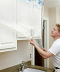 Man using Pro Grade Masking Film Kit With Static Cling 8 Rolls Of 48 In By 180 Ft Each Keeps Film In Place, flake resistant.