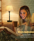 Woman reading by bedside table lamp with beige fabric shade, highlighting Bedside Table Lamps Set Of 2 With Dual USB Ports And Built In AC Outlet For Easy Nightstand Charging Fabric Shade Dope Modern Night Lights For Bedroom Living Room Or Office Bulb Not Included.