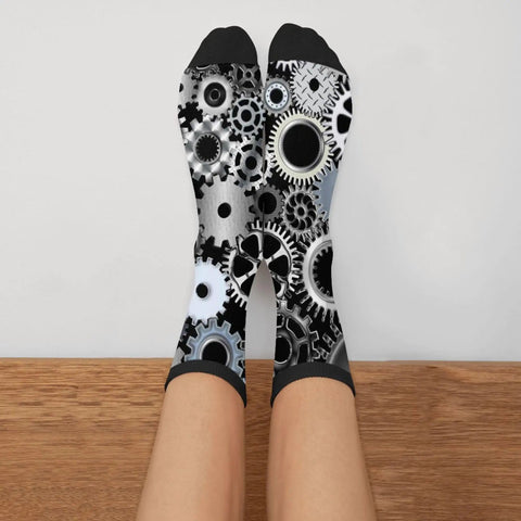 Person wearing Gearhead Engineering Crew Socks for Men and Women Funny Mechanical Novelty Footwear Unisex One Size Fits Most 98 Polyester 2 Spandex Soft Durable Knit Fits Mens 7.5 to 12 Womens 5.5 to 10 Great Gift Idea for Engineers and Tech Fans featuring mechanical gear pattern in black, white, and gray.