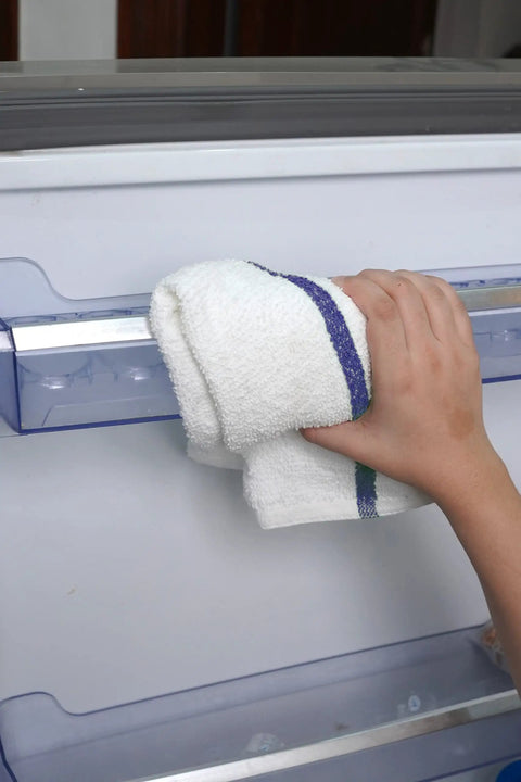 Hand using Bar Mop Towels Value Pack Of 60 16x19 Inches Absorbent And Durable Cleaning Rags for cleaning appliance surface