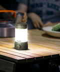 CL26R Pro Camping Lantern Olive Drab 650 Lumens USB C Rechargeable on wooden table during campsite dinner